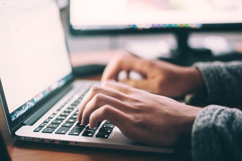 Inimene trükib arvutiklaviatuuril.